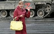 قدم زدن زن قرمز پوش روسی در کنار تانک‌های واگنر